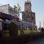 Die alte Straßenbahn, ein Geschenk der Stadt Nürnberg. Es gibt drei Doppelzüge, die eine nette Fahrt entlang der Küste und entlang der alten Stadtmauer ermöglichen. Im Hintergrund der Uhrenturm von Antalya.